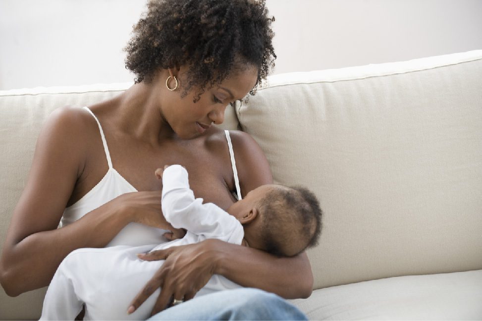 a woman of color breastfeeding her baby