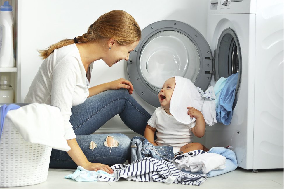Woman doing laundry next to baby