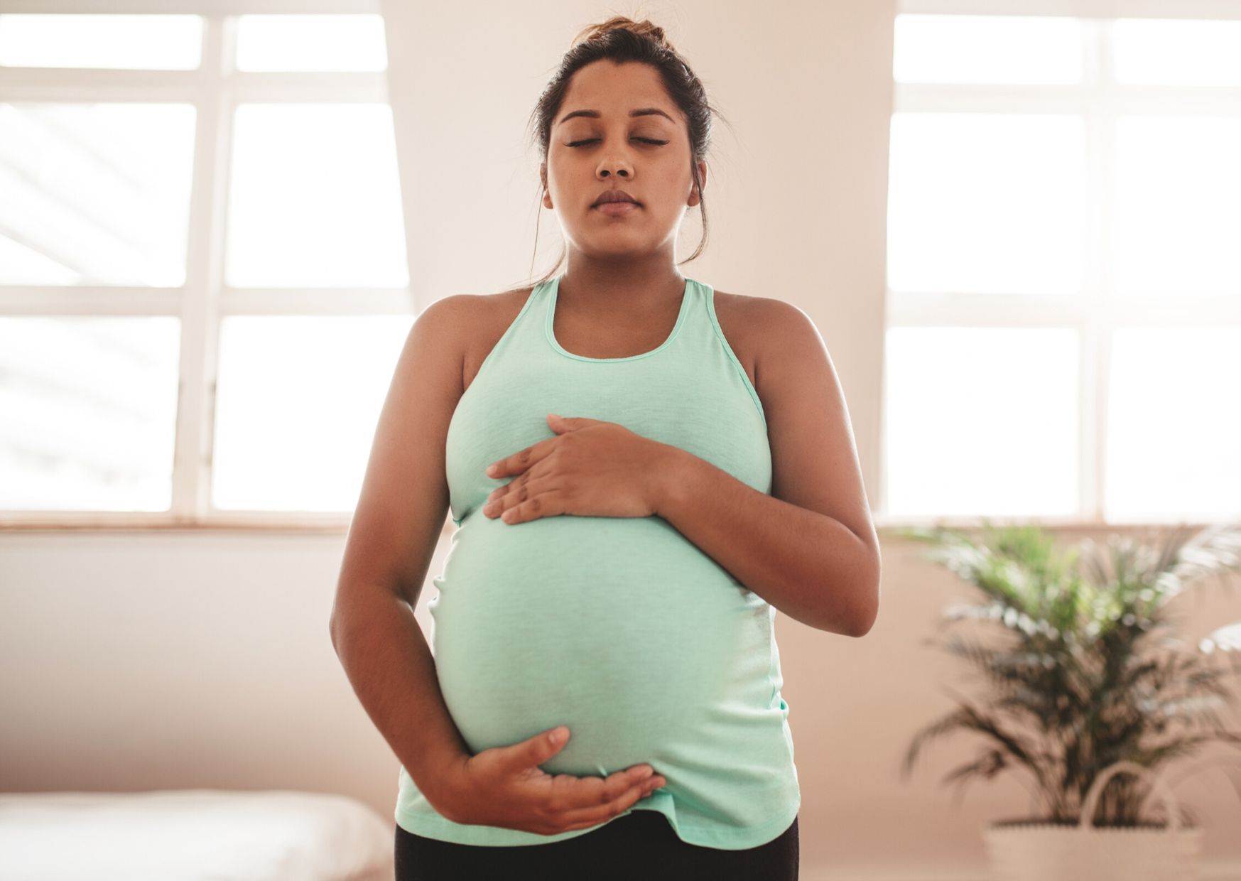 Pregnant woman in active wear holding belly